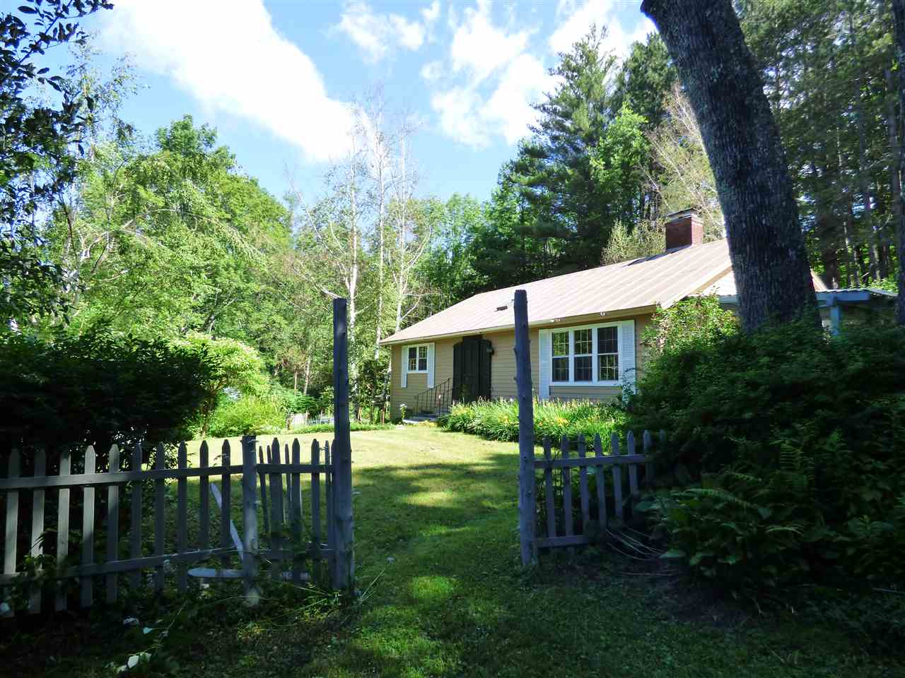This charming home is tucked away with verdant...