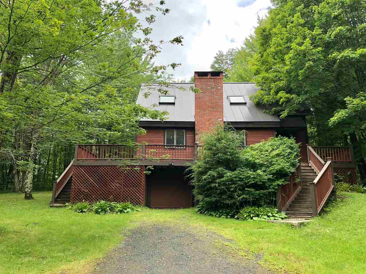 Nestled on a gently sloping wooded lot, with...