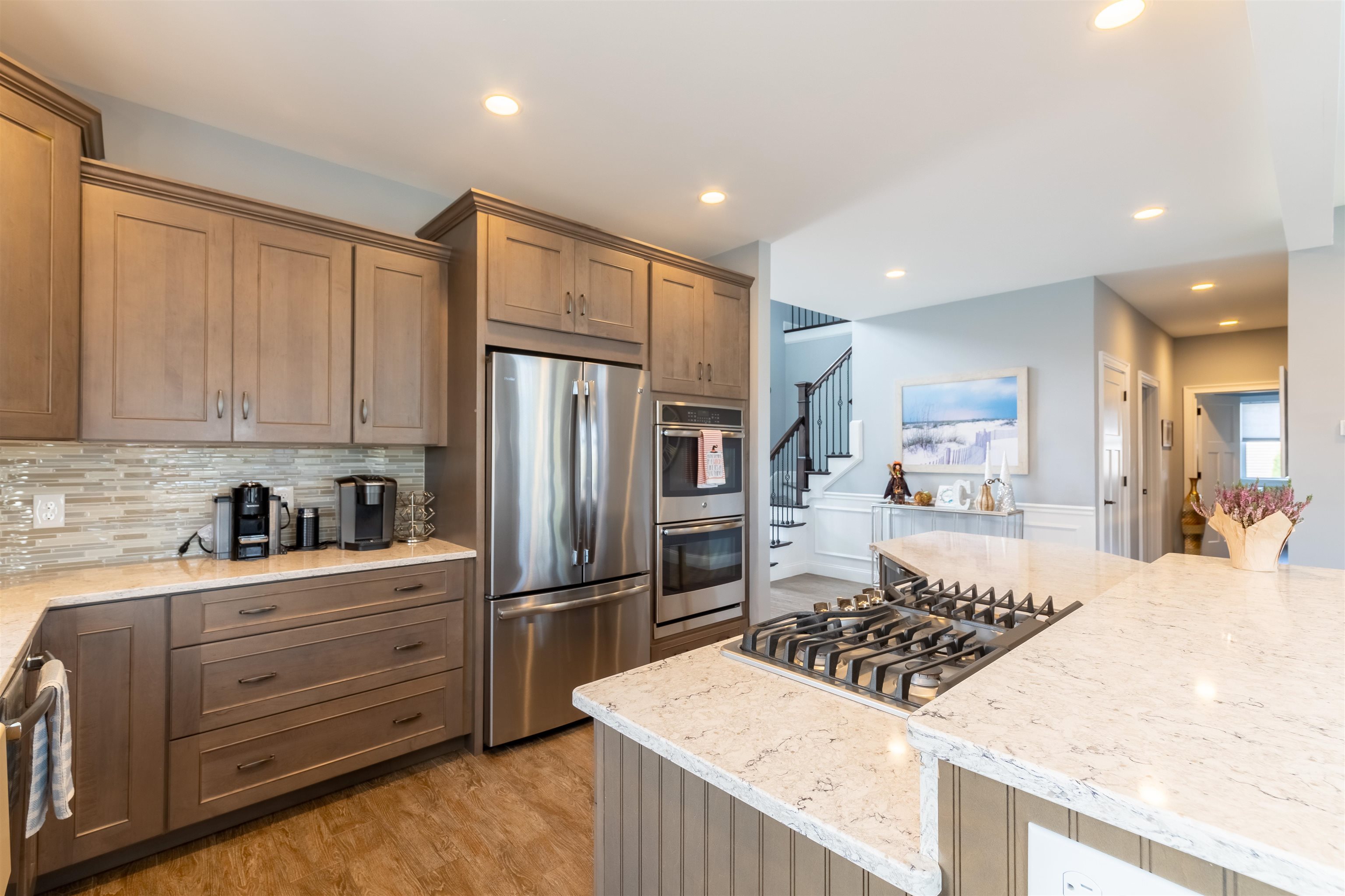 Kitchen island is set perfectly with modern design lighting, wine rack or possible shelving , beverage cooler and room for extra seating. Soft close cabinetry and GE stainless steel appliances