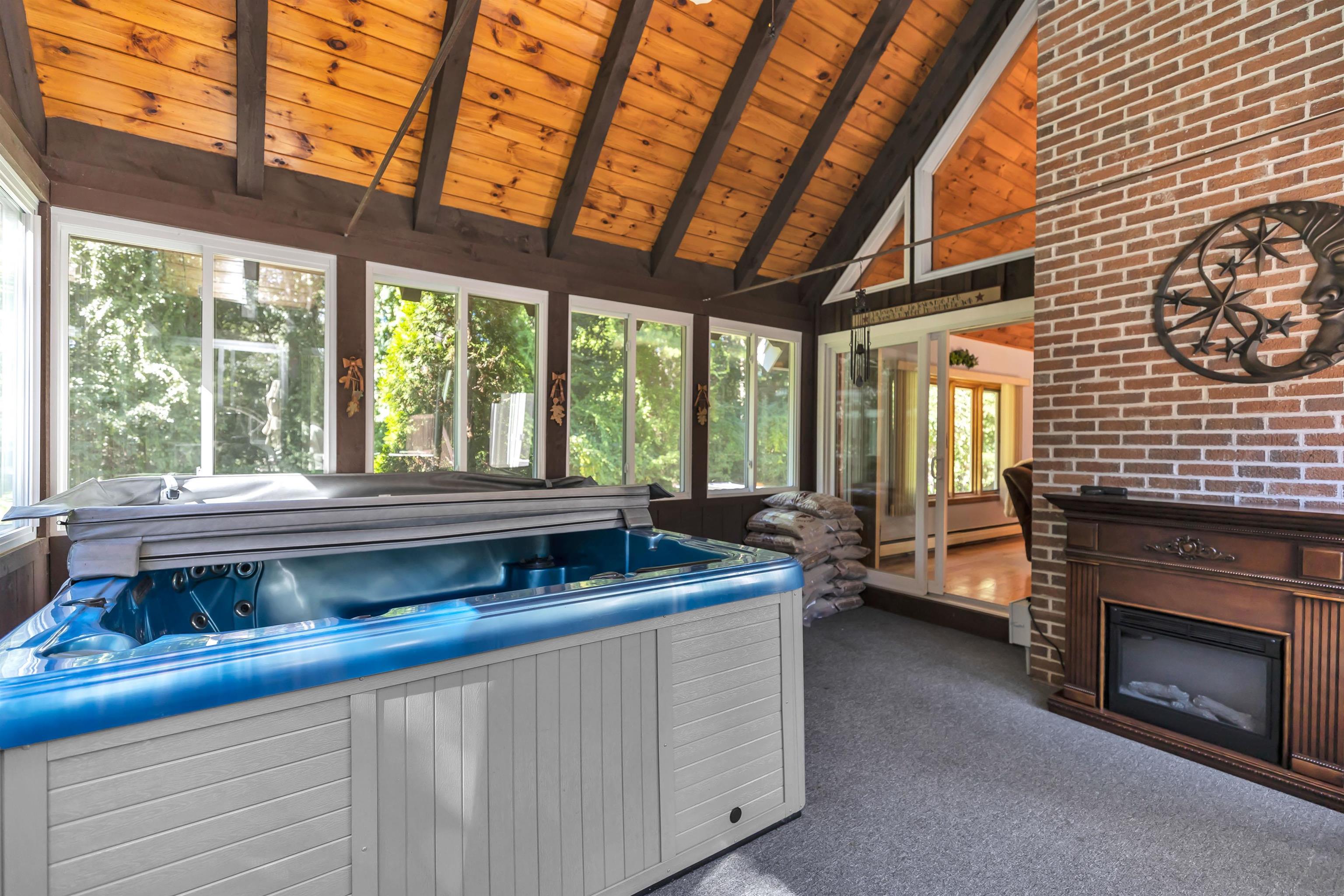 Enclosed porch with hot tub and electric "fireplace"