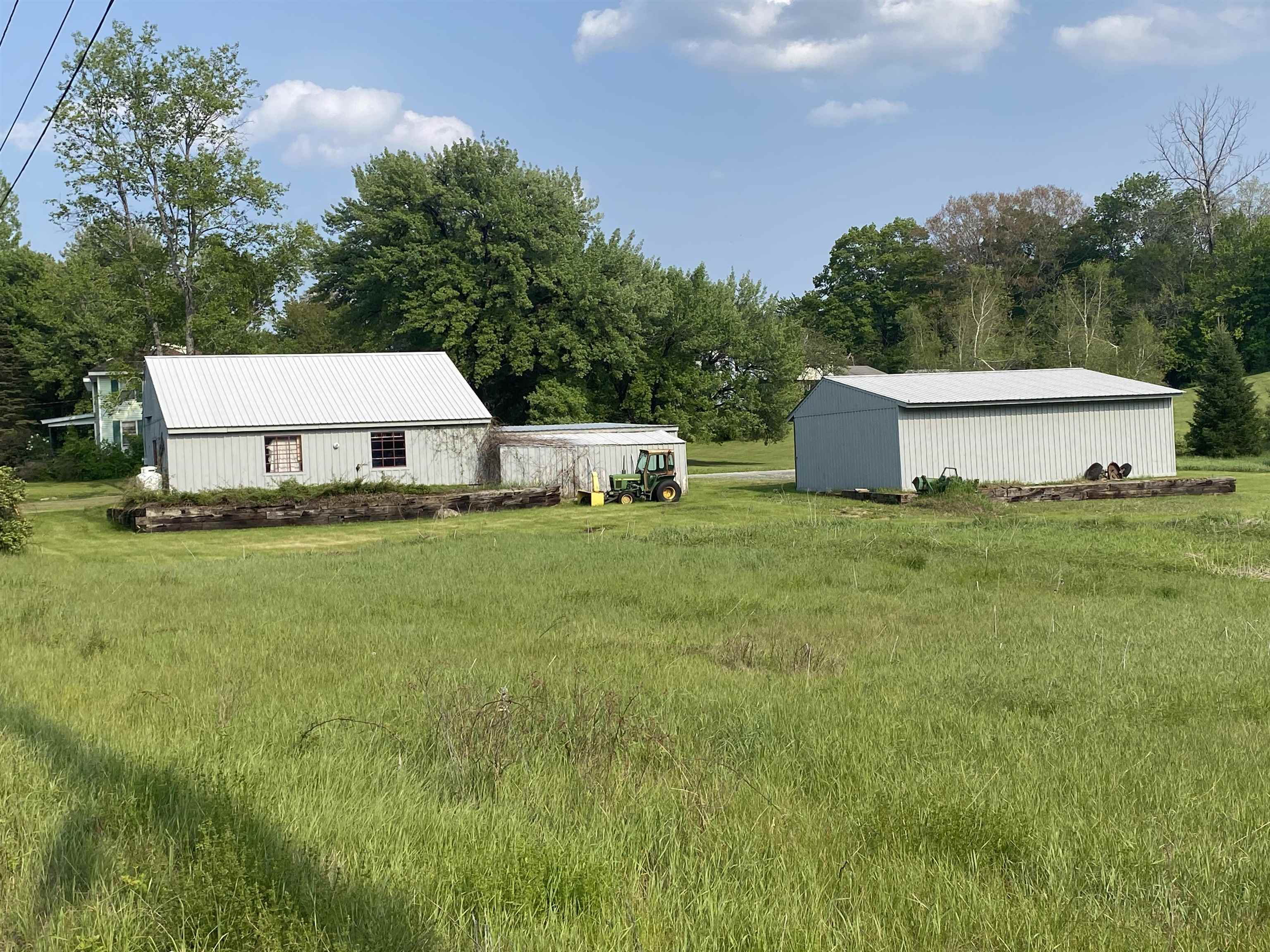 Showing the backside of both barns from one corner of the lot.  Nice field for horses!