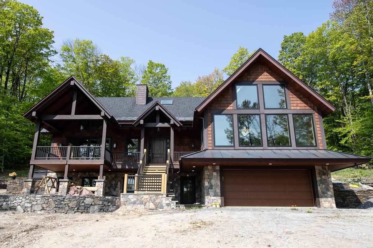 This beautiful and very spacious newly constructed home, with energy efficient upgrades, has over 6,000 square feet of living space on three levels. Within walking distance to the slopes, located close to the Base Lodge area, this home has everything a ski home needs. Enter through the carefully crafted front door into one of the two mudrooms, or through the two car garage or by the side mudroom and you will see walls of three-pane glass picture windows (for insulation and acoustics) looking at your mountain range view. An open floorplan with vaulted ceilings, large chef's kitchen with an island, hickory flooring, dining and living room with a fireplace that has a metal insert with internal blowing. There are 5 and a half bathrooms, plenty of spacious bedrooms, and a beautiful media/recreation room with a wall of windows, vaulted ceiling and view, which will be a fun space for entertaining guests! A hot tub, and covered porch/deck add to the exterior ambiance. Radiant heat on the ground floor, air recuperation system, 2x8 walls, foam insulation in walls and roof and more!