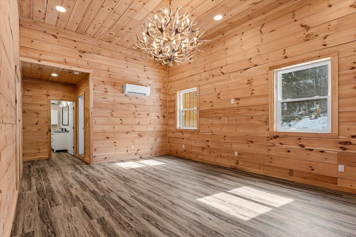 This fully converted home offers a unique blend of contemporary, modern comfort and rustic Vermont charm. Set on a peaceful, wooded 6.1 acre lot just 10 minutes from Okemo Mountain Resort, this versatile space is ready for your personal touch. Once a garage, it is now a stunning modern retreat, that is waiting for you to move in. The spacious ground floor features a large living area, a comfortable bedroom, and a full bathroom. Upstairs, you'll find a bright kitchen and dining area, an additional ¾ bathroom and a cozy family room with a sunny raised deck - perfect for entertaining or relaxing after a day in the mountains. This unfurnished home is a blank canvas, waiting for you to make it your own. The property also includes a versitile barn with plenty of extra storage. Whether you're seeking a unique primary residence, a weekend getaway, or a rental investment, this Mount Holly gem is an opportunity not to be missed! This property is also being offered two other ways: house, converted garage and barn on 16.5  acres (MLS #5032246) or house only on 10.4 acres (MLS # 5032249).