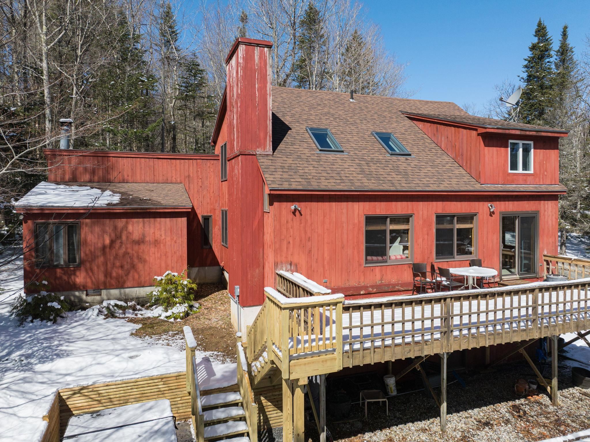 Spacious 5-bedroom, 4-bath home with additional designated office space, den and 2 car garage on 1.17 acres! Thoughtful floor plan includes a first-floor primary suite with wood-burning fireplace, a guest bedroom and full bath, a private office with its own full bath, and a large mudroom with laundry and storage. The open living room with vaulted ceilings, wood-burning fireplace, and abundant natural light is an excellent gather space. Smartly designed kitchen with adjacent dining room that opens to the back deck. Just steps down to the back yard and hot tub. Upstairs features three generous guest bedrooms, another full bath, and an open hallway that brings in great light throughout the home. The lower level includes impressive storage, lockable owner closets, a den ideal for TV or games, and direct access to the two-car garage—a rare feature at this price point. Set on 1.17 acres with established landscaping, rhododendrons, and evergreens. Just minutes to Mount Snow, the Hermitage Club, downtown Wilmington and close proximity to Southern Vermont amenities, shopping, golf, lakes and outdoor adventures. A great value, checking all of the boxes, in a perfect location.