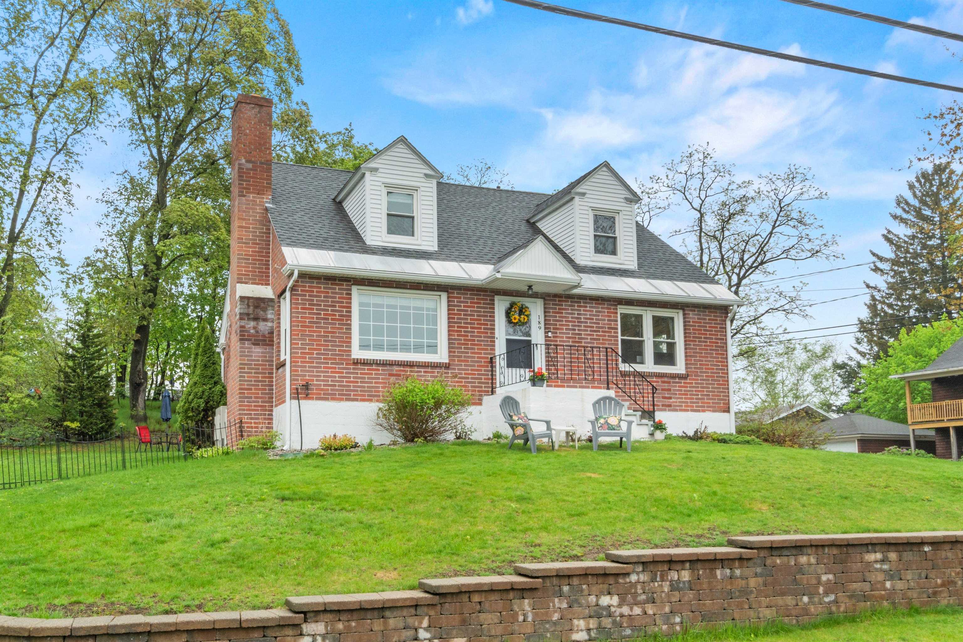 Lovely view of the fully-dormered brick front & yard from the street! 23152184