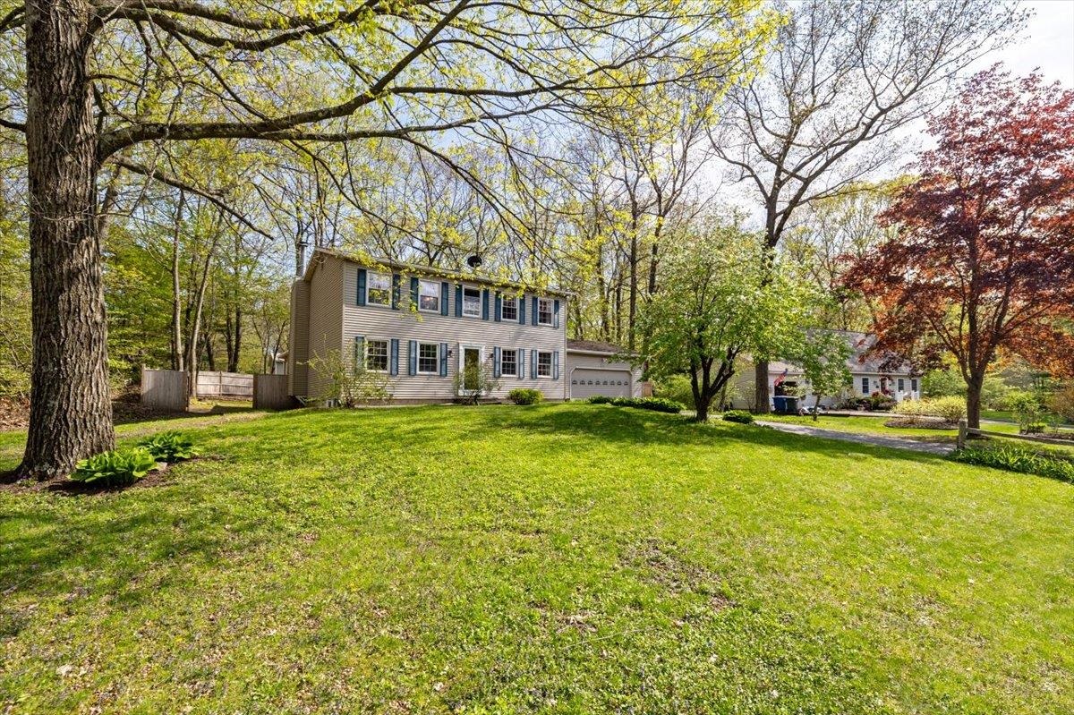 Drive into this sought out neighborhood to your beautiful new home! Spaced well from the neighbors with mature trees to give privacy, this four bedroom home is ready to be yours. Allow guests to enter the front door by way of the brick walkway, while you enter through your garage into the large mudroom. Inside you'll find a newly remodeled kitchen with a large island and a connecting dining room. Unlike typical colonial houses, this space has been opened and is perfect for gatherings. You'll also find a family room, living room, half bath, and an amazing sunroom, complete with a gas fireplace for those colder Vermont days. Out the back of the sunroom, you'll find the fully fenced in backyard, complete with a no dig dog fence to keep your pet safe and contained. The backyard also boasts a deck, patio, and shed for all your exterior storage needs. Make your way upstairs to find a full bath, three large bedrooms, and the primary suite. Head down to the basement and you'll find a dry storage area with laundry, a work bench, and a newer on demand water heater. On the finished side of the basement is another great entertaining space, complete with a dry bar area. Many new improvements to this house leave nothing for you to do. Come see it today and get ready to spend your summer by the community pool and playing on the courts.
