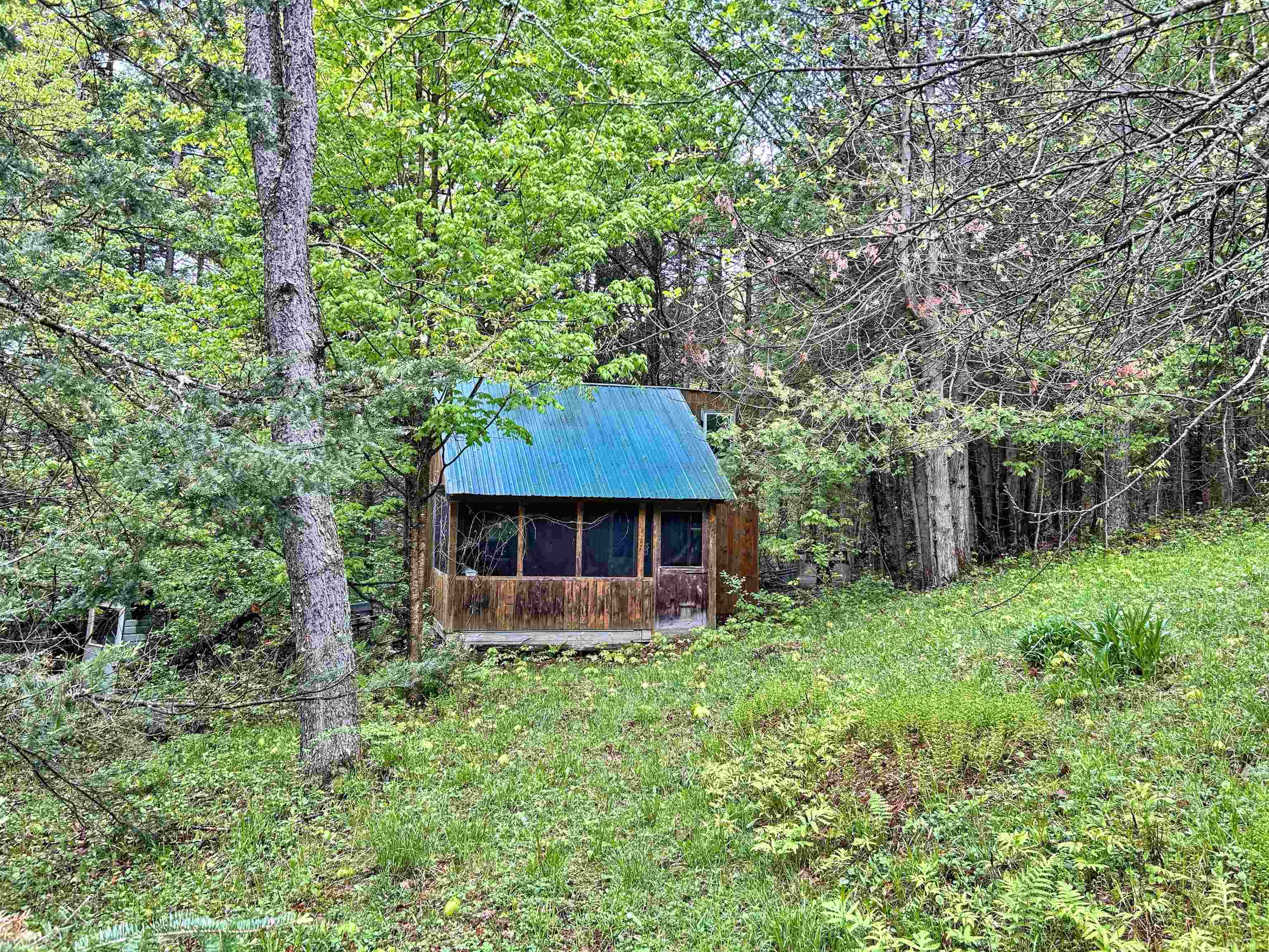 A nature lover's retreat near Lake Parker: Discover a charming property brimming with potential, just a stone's throw from Lake Parker. Bordering the Stevens Brook and crisscrossed with abundant wildlife trails, this land offers a unique opportunity for as private hunting camp or a building lot for your home. A cozy 12'x20' cabin rests serenely on a rise, overlooking a picturesque apple orchard nestled within the woods. Enjoy peaceful moments on the 8'x14' screened porch, surrounded by nature's beauty. The property also features a tiled spring and convenient electrical power already in place at the pole. Your vision awaits just a quarter mile from the shores of Lake Parker.