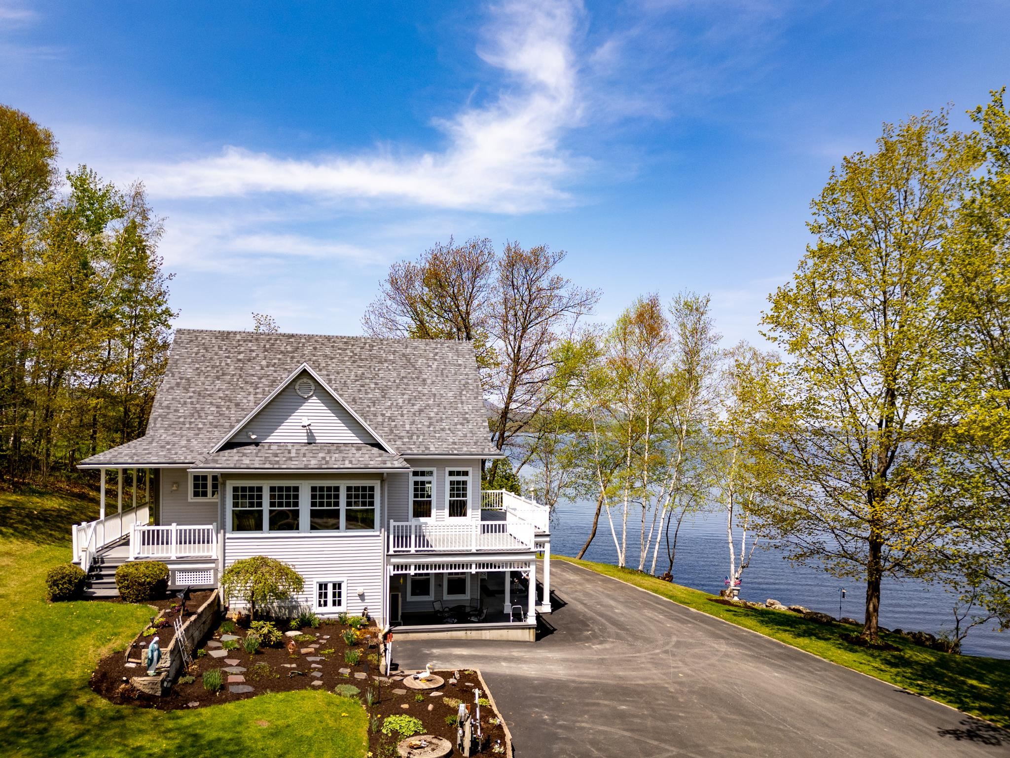 Stately Lakefront home resting majestically on 7.2 deeded acres overlooking Farrants Point, Owl's Head, Bear Mountain, and views into Canada. Live comfortably in this well-appointed home with 3 finished floors, lots of natural light, 2 full kitchens, w/ open floor plan. All floors with wrap around decks/patios to enjoy the mesmerizing views of Lake Memphremagog Sunrises.  Choose from several beaches on the properties, even catch the Sunset views off Farrants Point!  Do you have a sea plane?  You can land it here... You can boat across the bay for fine dining at "The Eastside" Restaurant, which includes a Pub, Bakery, and Boutique Shopping! Plenty of room for all your hobbies with a 5 bay garage including 1 w/ radiant heat, 1 w/ lift, separate chicken coop, and a 72'LX32' WX35'H Boat House w/27' door, includes prep kitchen, office & balcony! Stroll along the point to enjoy the natural habitat w/ nesting birds, or fish off the point.  Great swimming, boating, fishing, and opportunities to recreate.  Minutes to Interstate, Airport, hospital, hiking and biking trails, 25 minutes to Jay Peak Resort, and easy travel to Boston, Montreal, and Burlington. Bonus of municipal water & sewer...imagine an art gallery, a gated community, a wedding venue, it's an open canvas ready for the new owners to cherish. (Much of the Boat House, & garages equipment/furnishings will convey with sale, ask for details).  Once in a lifetime opportunity...