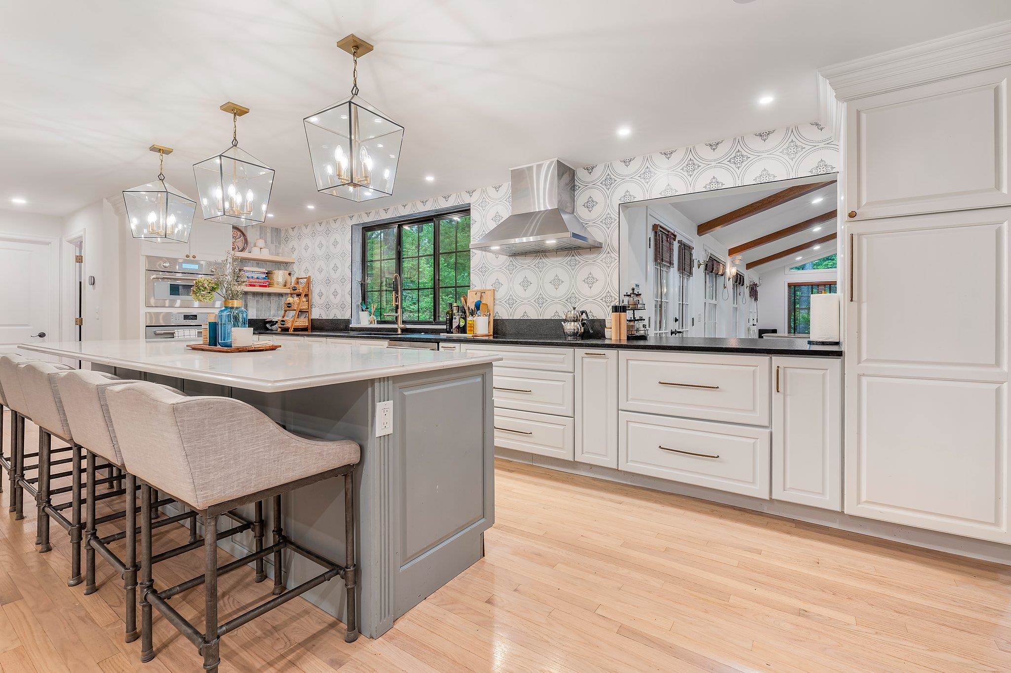 Step into timeless elegance with this custom-designed 5–6 bedroom, 3.5 bathroom Colonial estate, privately situated on a beautifully landscaped 1.16-acre cul-de-sac lot in one of Londonderry’s most prestigious neighborhoods. This exceptional property features a rare 4-car garage with workshop space, offering both functionality and ample storage. Designed for upscale entertaining and comfortable everyday living, the home boasts a chef’s kitchen that opens to a dramatic Great Room with cathedral ceilings, gleaming rock maple flooring, a wood-burning fireplace, and double doors leading to a spacious deck overlooking serene wooded surroundings. The main level also offers formal dining and living rooms, a cozy den, bright home office, stylish half bath, and a well-appointed laundry room. Upstairs, the luxurious primary suite includes a private en-suite bath, complemented by three additional generously sized bedrooms and two full baths. A finished attic provides a flexible fifth or sixth bedroom or bonus room. Additional highlights include a newer HVAC system, 200-amp electrical with subpanel, standby generator, full unfinished basement with mudroom access, and an irrigation system. Elegant, spacious, and move-in ready—this is one of Londonderry’s finest homes.