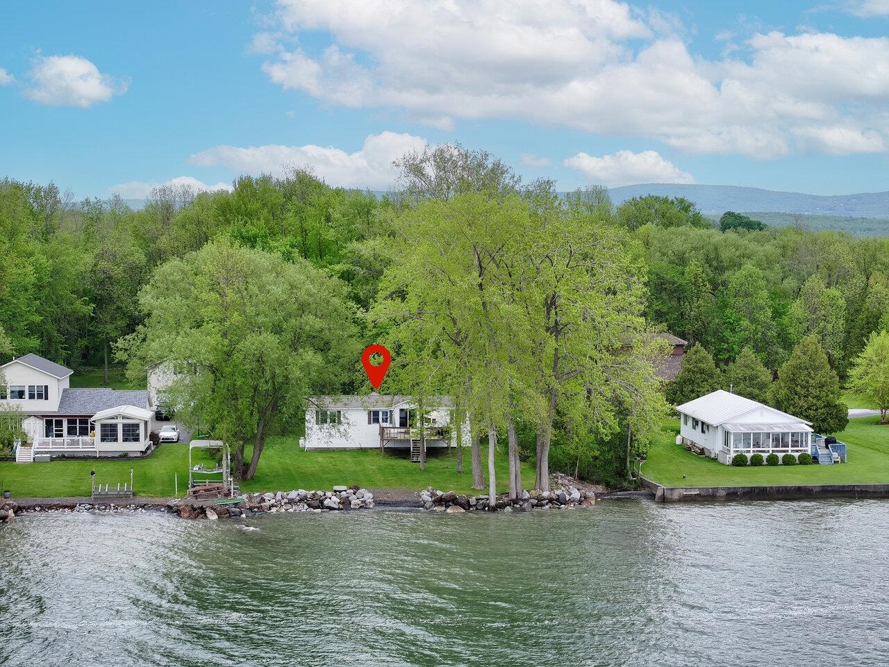 Discover your own slice of paradise on Maquam Shore in St. Albans, nestled at the end of a private road on the sought-after “Gold Coast” of Lake Champlain. This serene lakeshore retreat offers 100 feet of direct frontage, showcasing breathtaking sunsets and panoramic mountain views. A dream for boating and water enthusiasts, enjoy swimming, fishing, sailing, water skiing, paddle boarding, kayaking, and more, right from your backyard. This inviting home features 4 bedrooms, 1.5 baths, an open-concept kitchen and dining area, a cozy living room with fireplace, and an oversized back deck perfect for entertaining or simply soaking in the stunning lake views. Additional highlights include a 1-car garage, a new roof (2018), and easy potential for year-round living. Located on a private road with just 8 homes, this property offers unmatched tranquility and charm. Amazing lakeside living awaits - come jump in the lake!