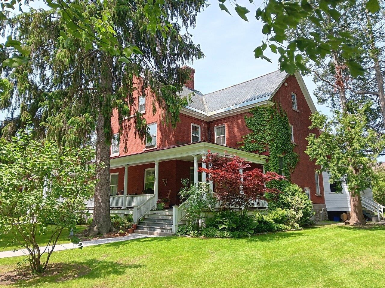 Located on Officer's Row in Fort Ethan Allen, this well-maintained 2-bed condo offers a warm & bright atmosphere, refinished wood floors, storage, room to spread out, & charm that comes with living in the Fort. Enter under a shared covered porch, where each unit is afforded its own space to enjoy unto themselves, surrounded by mature landscaping & accented by a gorgeous Japanese Maple. This 2nd story 2-floor unit is located up a beautiful, wide wooden staircase w/storage cubby & large window for immediate natural light. The top of the landing extends the length of the condo, leading to the kitchen. Across from the stair's top is the 1st bedroom, used by the current owners as a living room, w/a large closet, windows overlooking the park, & access to the 2nd bedroom. This 2nd bedroom offers more natural light & gleaming floors, another spacious closet, built-in shelving, & another door to the hall. The home's full bath w/tiled shower sits across from this bedroom, adjacent the stairwell to the 2nd lvl & shared basement storage/side entry. Along the hall you'll also find a walk-in pantry/storage rm w/built-ins. The kitchen sits at the hall's end, w/a brand new refrigerator, pantry closet, & ample cabinetry. The upper level features brick details, plenty of room to spread out, & laundry space. Back outside you'll find formal parking out back & the shared basement side entry. An oak park across the street w/walking trail, pagoda, & tennis courts is a wonderful bonus! Welcome home!