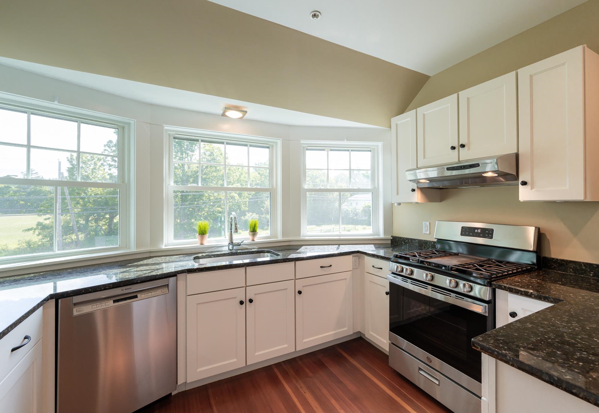 Lovely bank of windows and granite counters, sure to inspire all levels of chefs