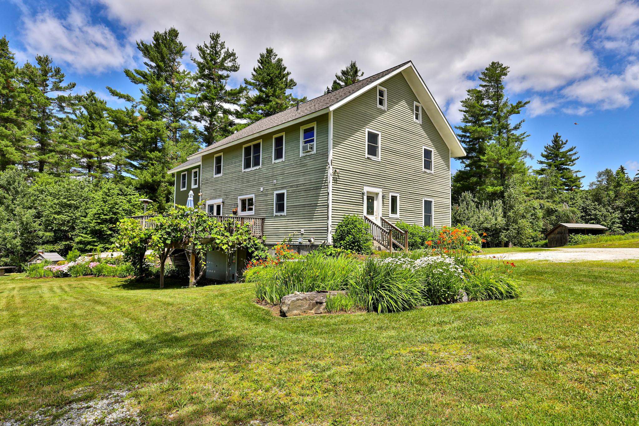Side entrance with walkout basement and garage door under deck