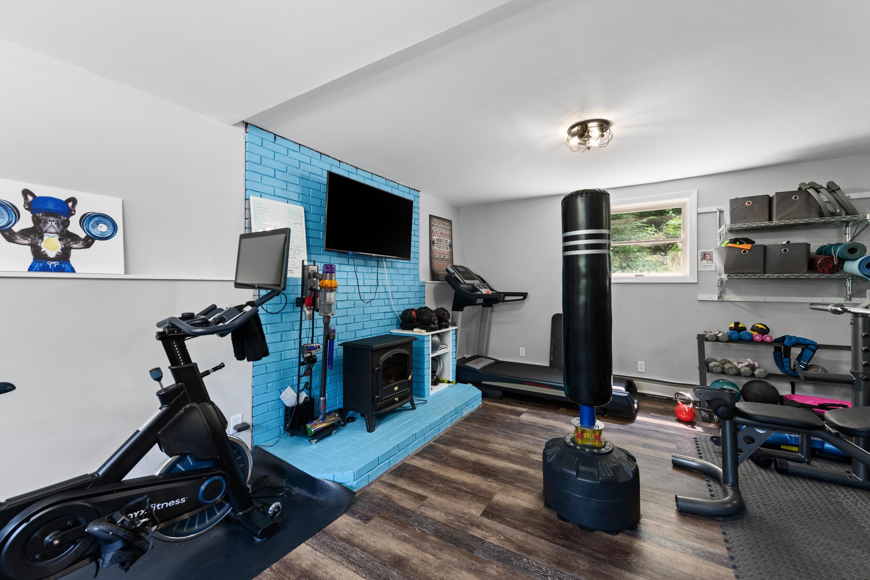 Family room they are using as a exercise room has new flooring and a wood stove hookup