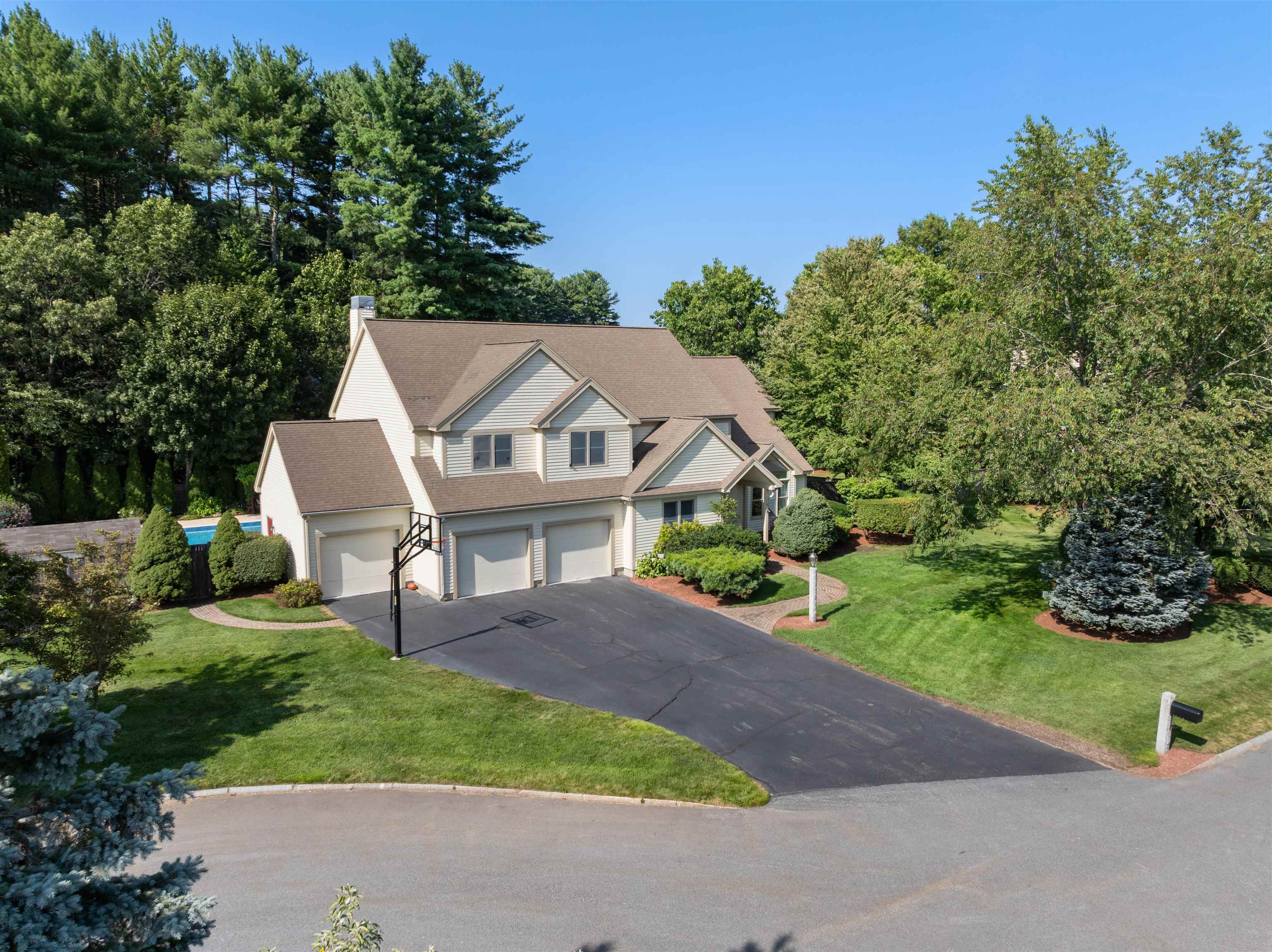 Grand 5-Bedroom Colonial in Nashua’s Bicentennial School District. Located just minutes from the prestigious Sky Meadow Country Club, this stately Colonial combines timeless design with modern comforts and resort-style amenities. Step inside to a dramatic two-story foyer and living room with a sweeping two-way staircase and elegant custom built-in bookcases that open into the formal dining room. The chef’s kitchen boasts an island with gas cooktop, high-end appliances, abundant cabinetry, and a sun-filled breakfast nook. A spacious family room with custom built-ins overlooks the stunning backyard, creating the perfect backdrop for everyday living and entertaining. Upstairs, the luxurious primary suite offers a spa-like bath with a tile walk-in shower, dual vanities, jacuzzi tub, and a walk-in closet with custom shelving. Four additional bedrooms and two full baths complete the second floor. The finished basement provides versatile living space plus generous storage, while the backyard transforms into your own private oasis with an in-ground pool. A 3-car garage completes this exceptional home in one of Nashua’s most sought-after neighborhoods. Showings begin Sat 8/16 at Open House.