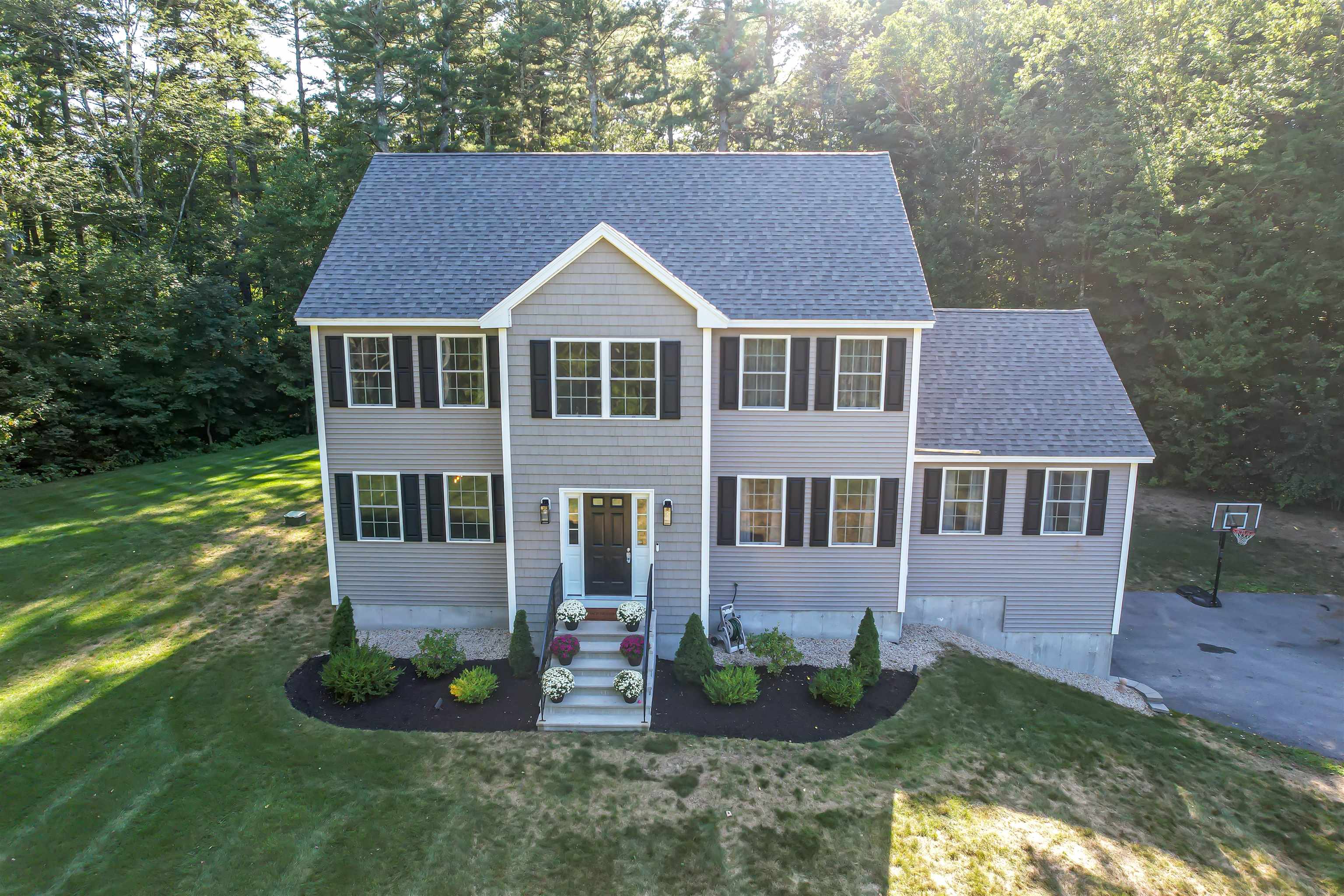 Your Dream Home Awaits! Nestled in South Londonderry near the Windham town line, this stunning contemporary Colonial offers the perfect blend of comfort, privacy, and convenience—just minutes from shopping, dining, and major highways. Set back from the road, the home provides a peaceful retreat with an unbeatable location. Inside, enjoy sun-filled rooms and gleaming hardwood floors. The chef’s kitchen is a true centerpiece, featuring quartz counters, white maple cabinetry, a large island, marble backsplash, and high-end KitchenAid Commercial-Style appliances—ideal for cooking and entertaining. The open-concept great room boasts soaring cathedral ceilings and a cozy gas fireplace, while the formal dining room is perfect for special gatherings. The layout flows beautifully, balancing open living with spaces of privacy and comfort. Upstairs, you'll find three generously sized bedrooms along with a luxurious primary suite featuring a walk-in closet and a primary bathroom with dual vanities. Bathrooms are finished with polished, marble-grained tile for added elegance. Additional highlights include a first-floor laundry room, attic storage, and a well designed functional floor plan. Don’t miss your chance, schedule a showing or visit our Open House Sunday, August 24th, 11 AM–1 PM!