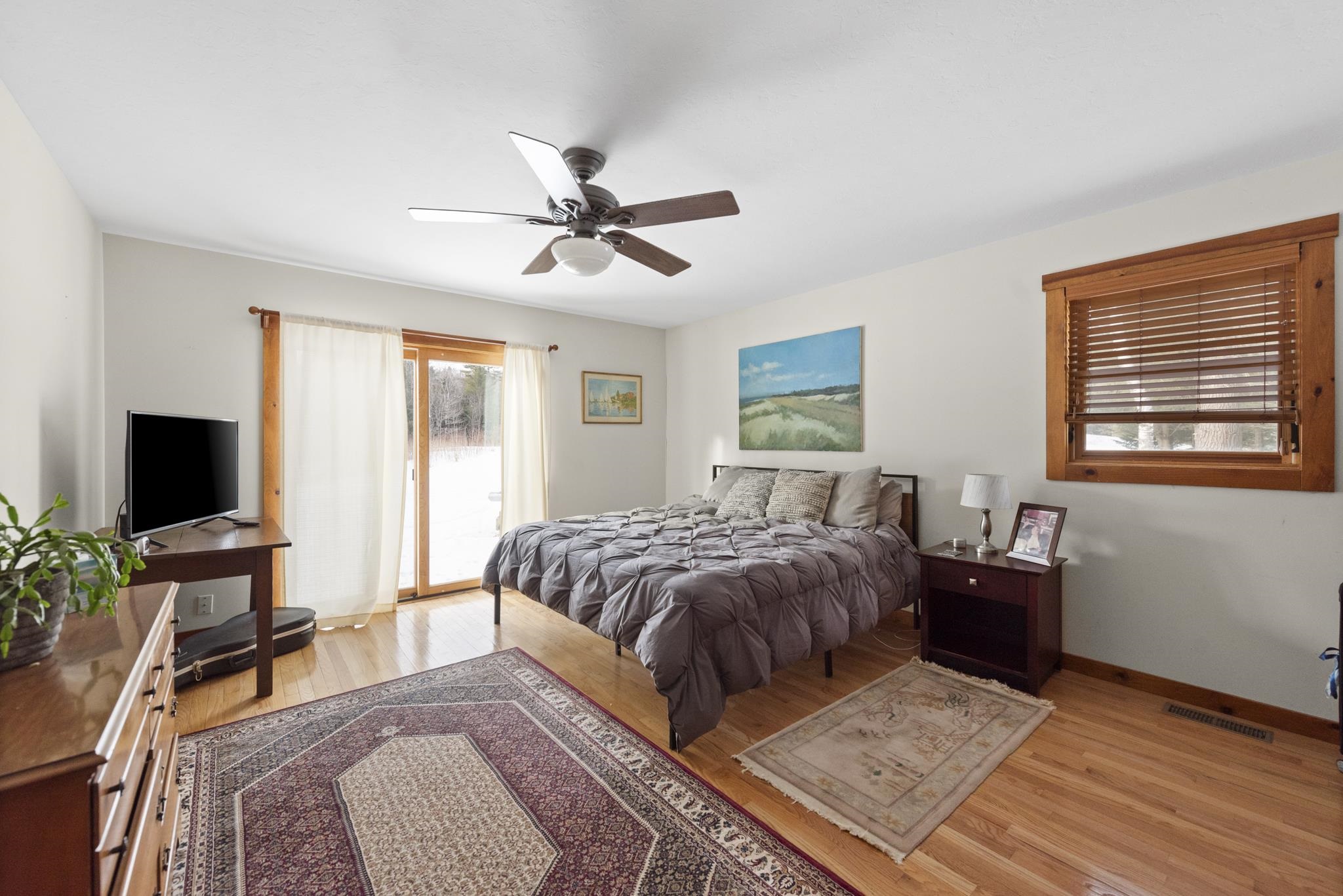 This bedroom features a walk in closet and opens up to a private patio surrounded by fruit trees