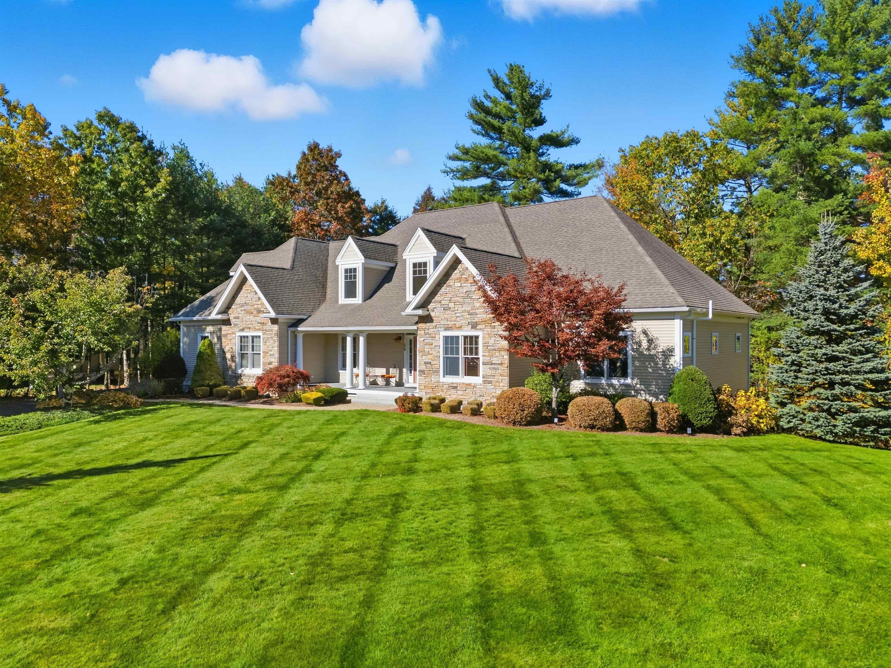 Welcome to 58 Tanglewood Drive,  located in the desirable Tanglewood Estates in Nashua, NH! This exceptional 3-bedroom, 3.5-bath home offers style, space, and an unbeatable setting. The open-concept kitchen flows seamlessly into a stunning living room, where floor-to-ceiling windows frame the fireplace and exposed beams add warmth and character. Exit right from the kitchen onto your expansive back deck. It’s an entertainer’s dream featuring a custom-built pergola with a fireplace, TV center, and sunken hot tub, all overlooking serene conservation land. The first-floor primary suite provides a private retreat with double closets and a spa-inspired bath complete with a soaking tub. Upstairs, you’ll find two additional bedrooms, a full bath, and an unfinished bonus room currently used as a gym, offering potential for a future fourth bedroom. The fully finished lower level is the ultimate game-day getaway, featuring a built-in bar, full bath, office area, and walk-out access to the back patio. 58 Tanglewood Drive truly has it all! Thoughtful design, modern comfort, and a tranquil backdrop. Don’t miss the opportunity to make it yours.