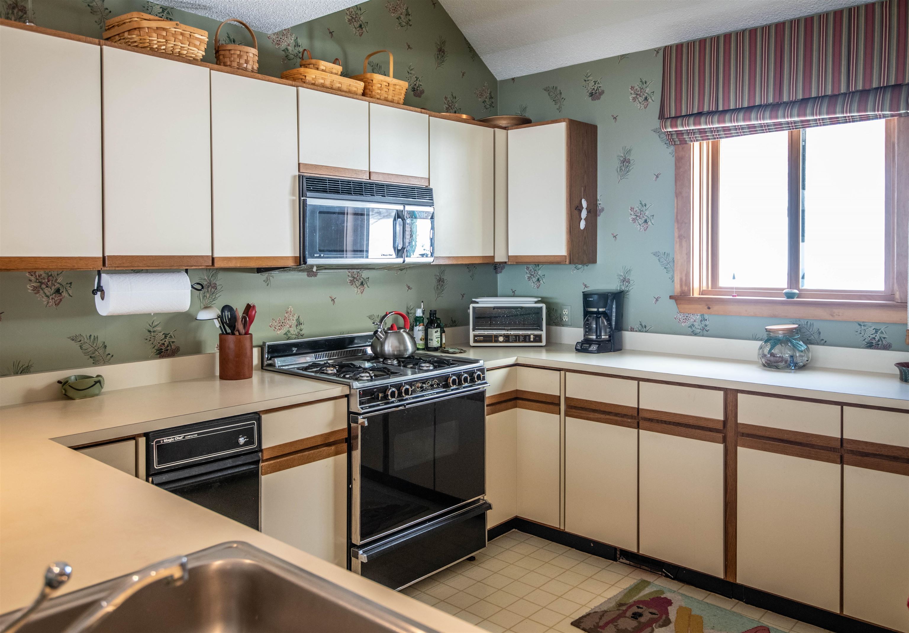 Large kitchen offers views of Okemo State Forest. 21086178