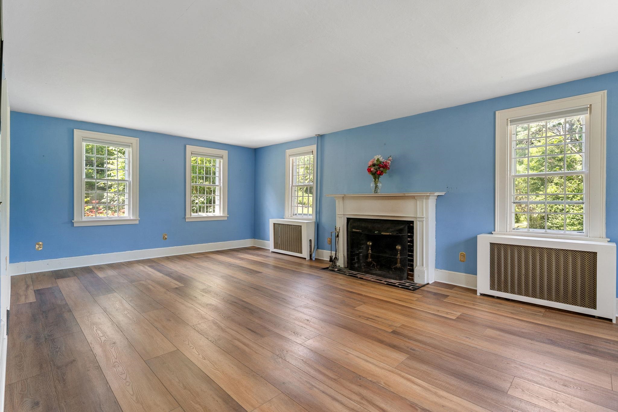The light filled living area with wood burning fireplace offers views of all ends of the property. 23714520