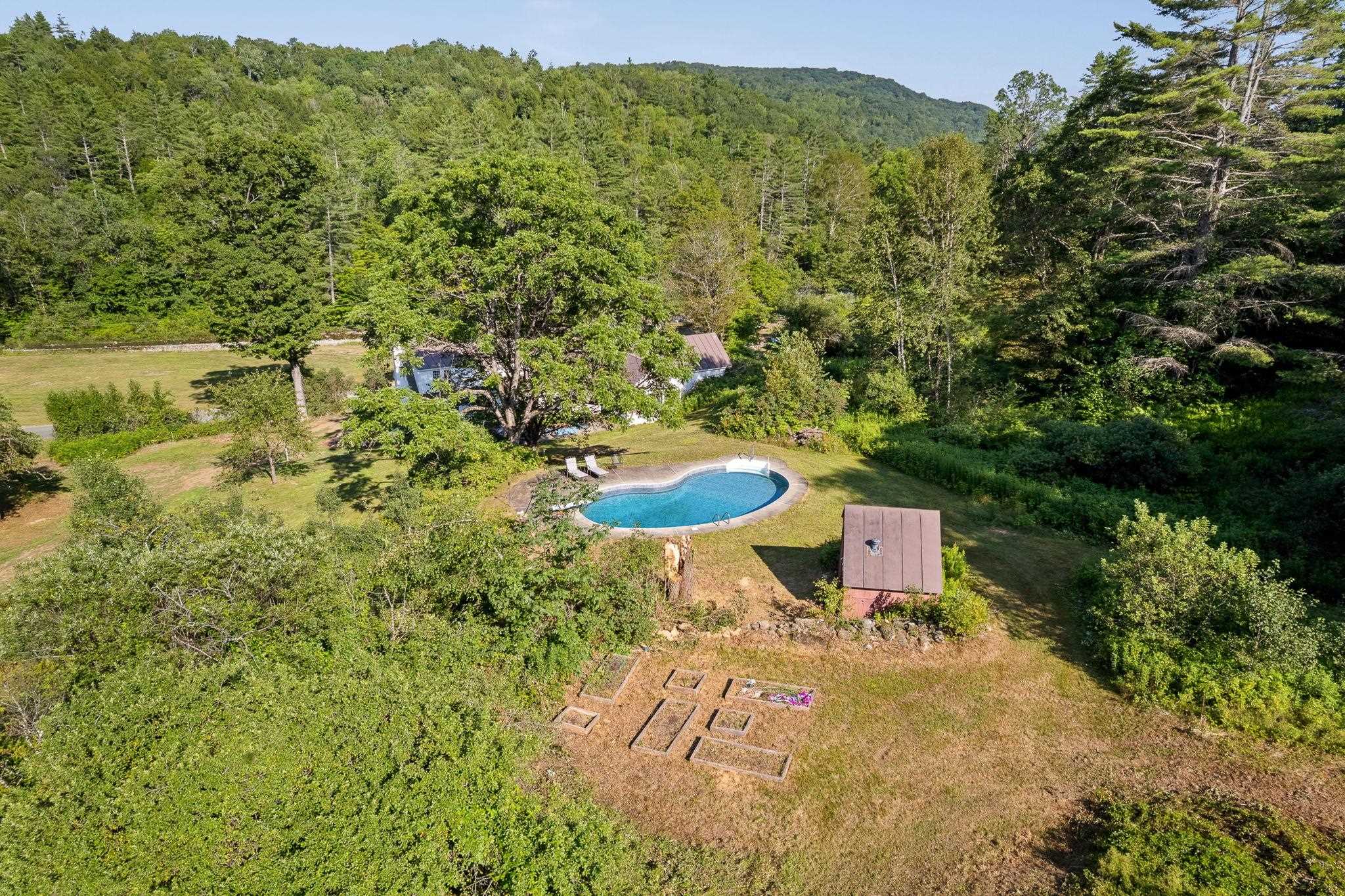 An aerial view of the gardens, pool, pool house and home down below. 23714650
